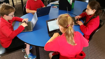 Students using the Chromebooks to complete their writing task. 