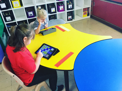 Students using Ipads during reading rotations.